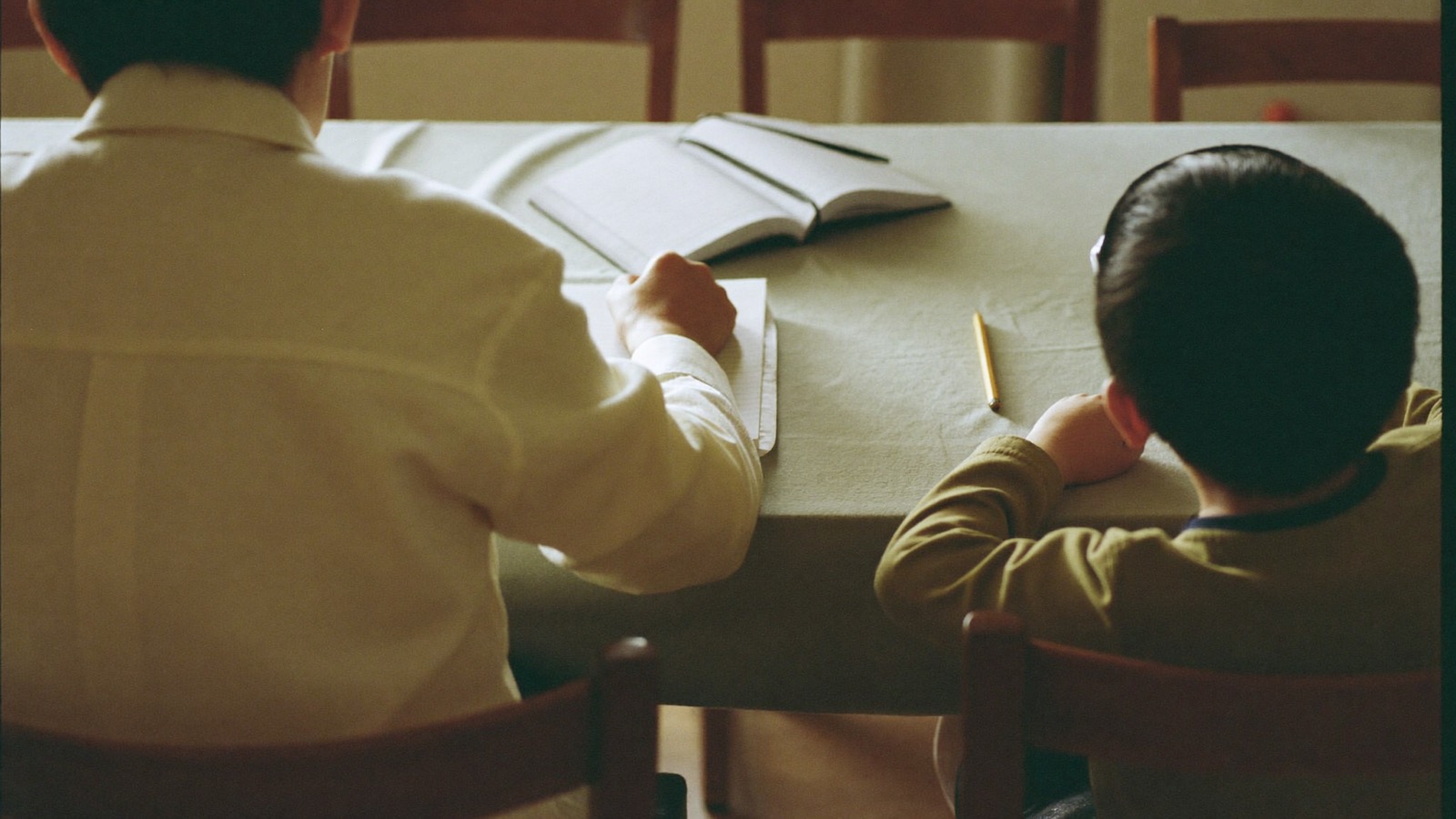 食卓で子どもと向き合う親の後ろ姿