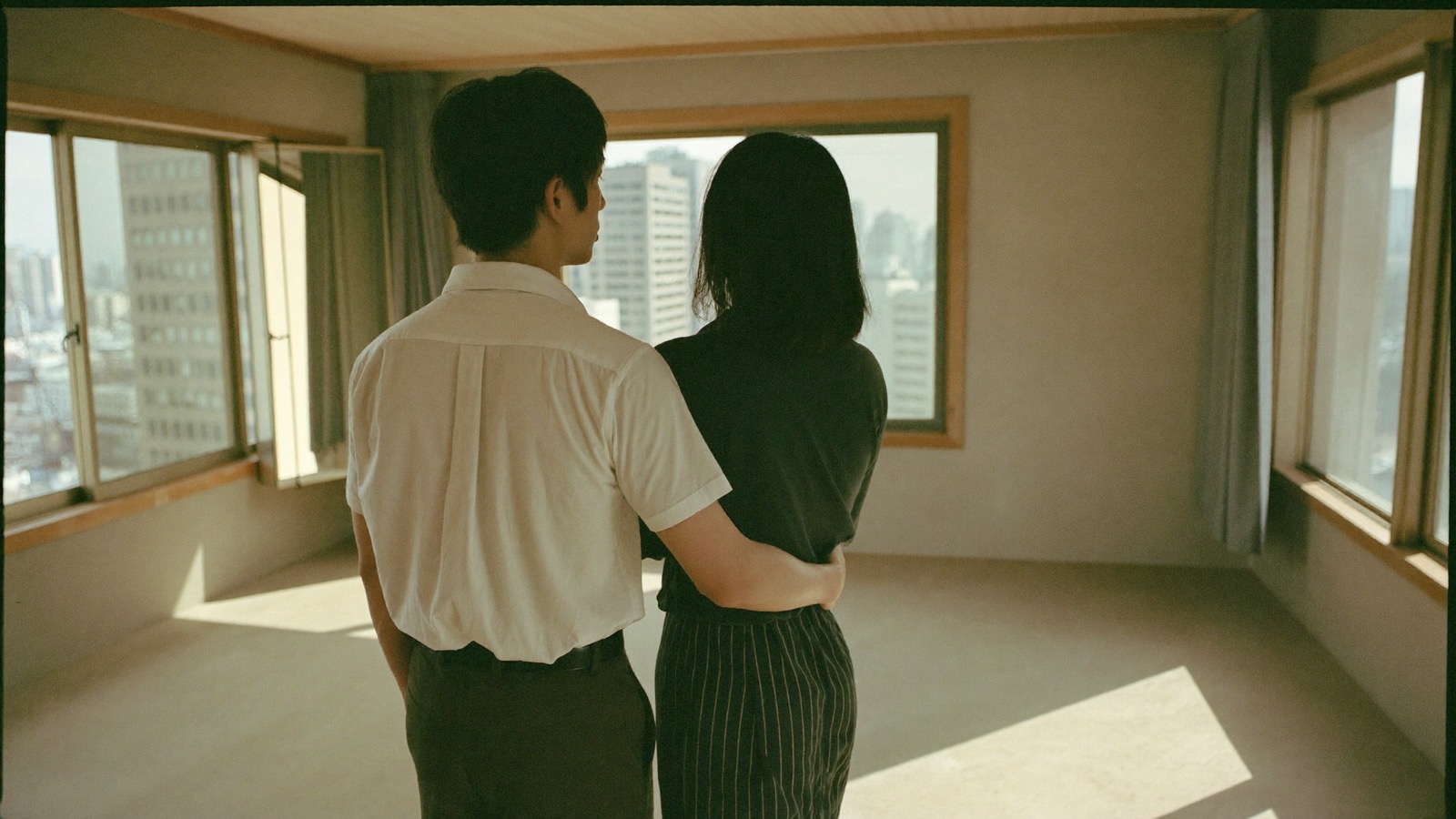 空室で外を眺める夫婦の後ろ姿